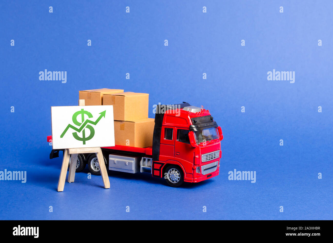 Red truck loaded with boxes and stand with a green dollar up arrow. Raise economic indicators and sales. Exports imports. High trade volumes, growth p Stock Photo