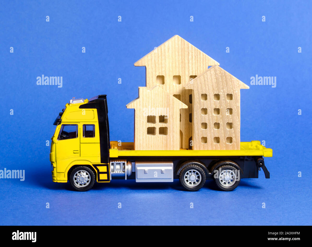 A cargo truck transports houses. Concept of transportation and cargo shipping, moving company. Construction of new houses and objects. Logistics and s Stock Photo