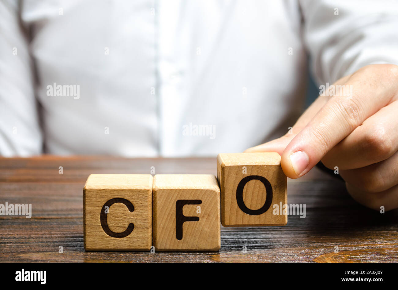 A man makes the word acronym abbreviation CFO. Chief Financial Officer