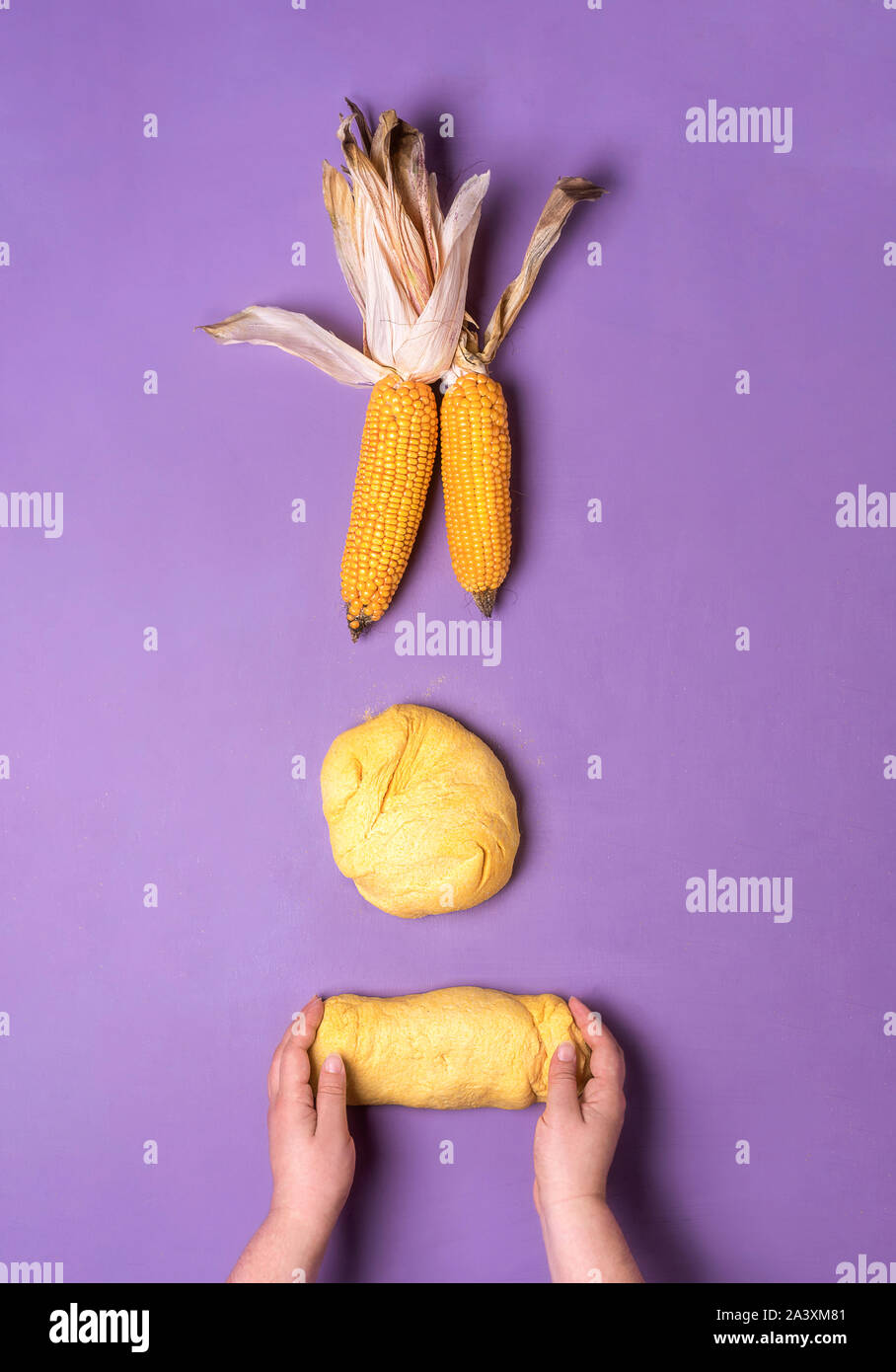 Home baking cornbread with woman hands handling corn flour dough over a
