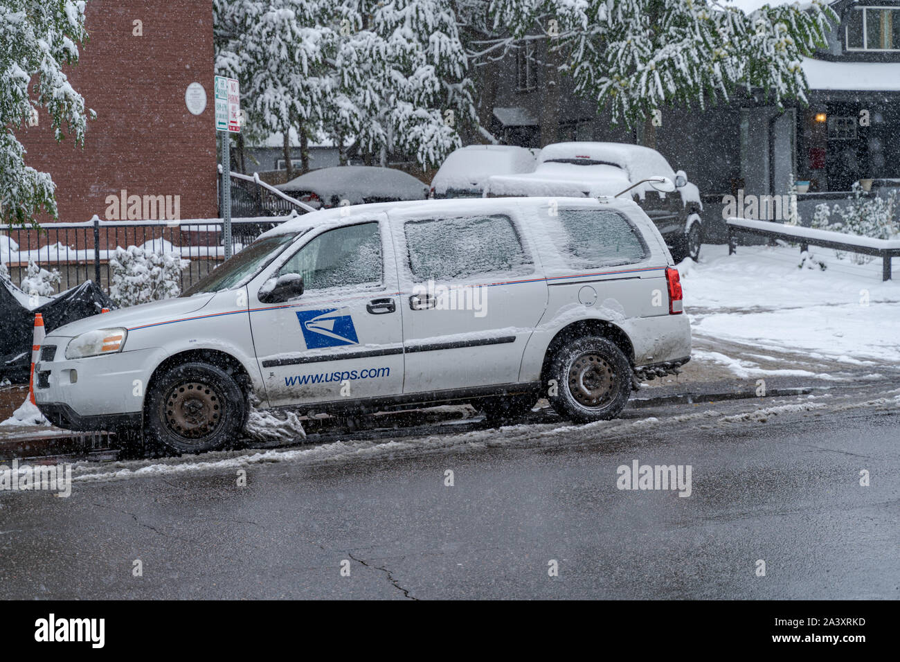 Denver, Colorado, USA- October 10, 2019: USPS delivery vehicle during Denver's first snow storm of the season. Stock Photo