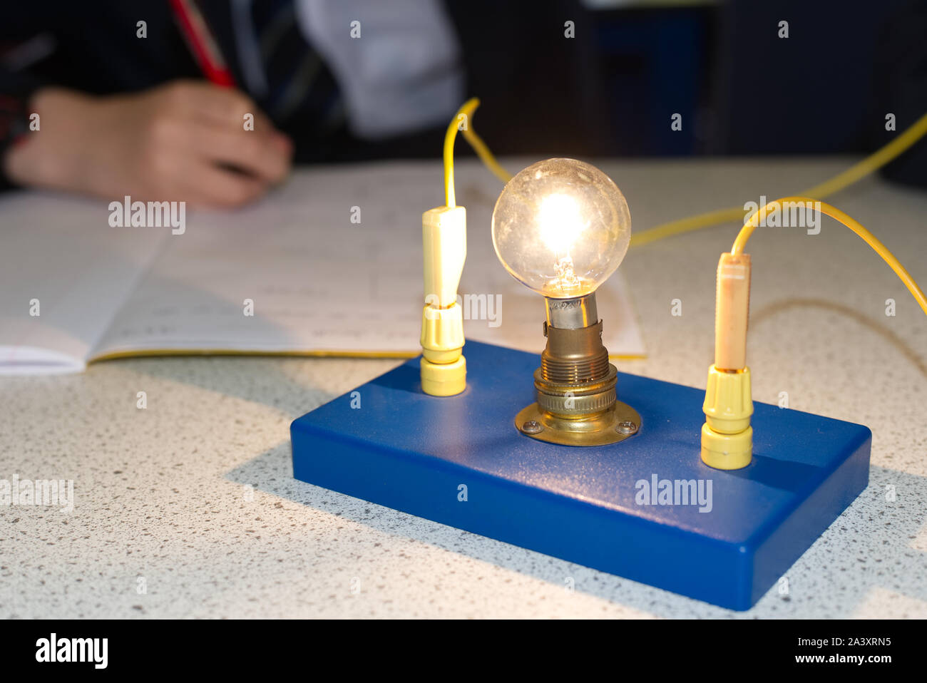 Light bulb in an electric circuit in a school science lab with students