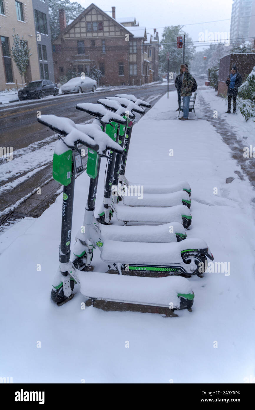Denver, Colorado, USA- October 10, 2019: electric scooters covered in snow during Denver's first snow storm of the season. Stock Photo