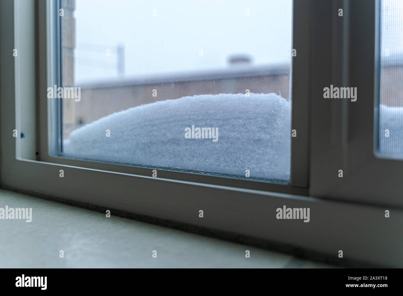 Window with snow accumulated on the lower part Stock Photo