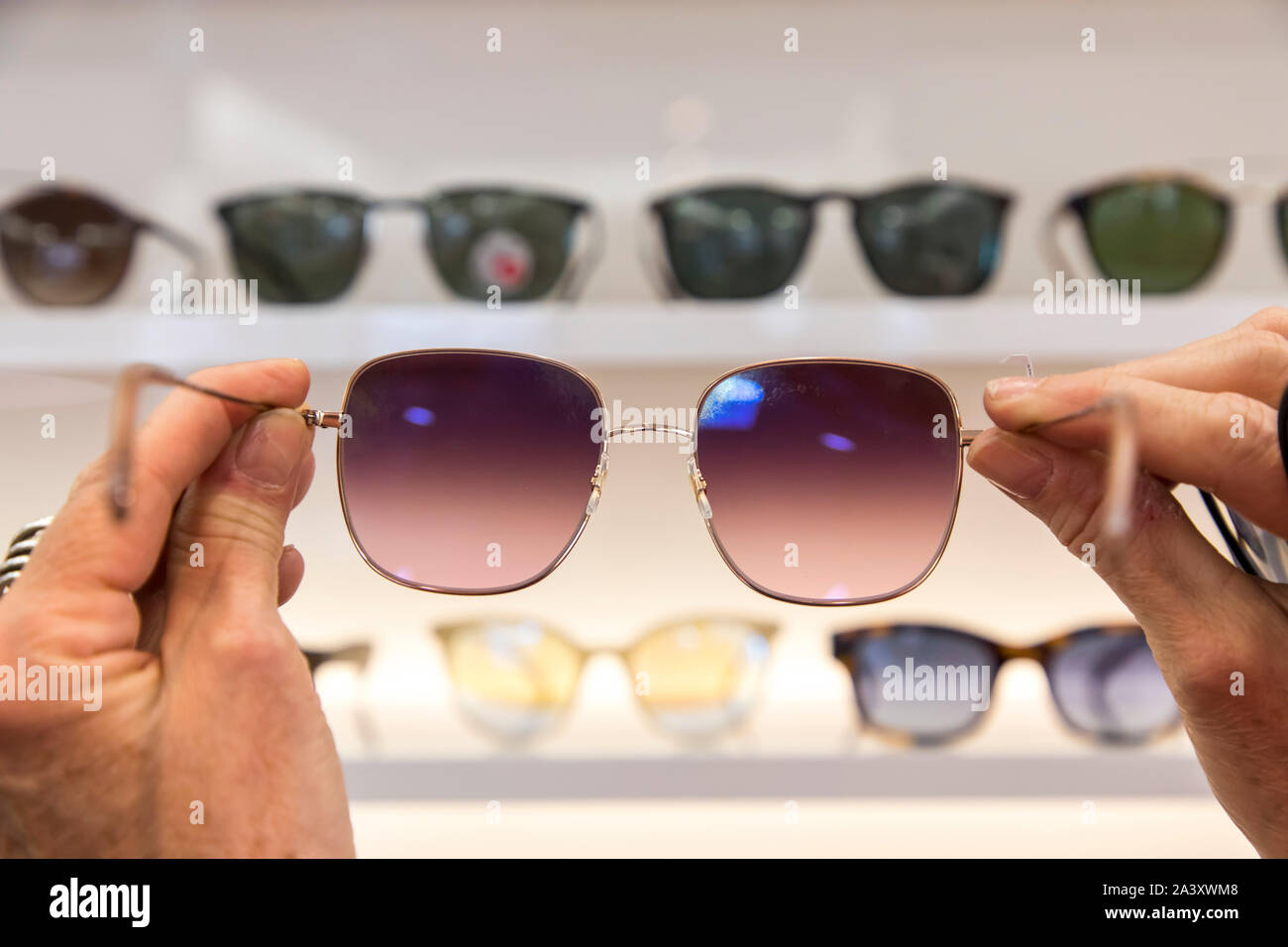 Optician, eyewear store, woman picking out sunglasses, Stock Photo