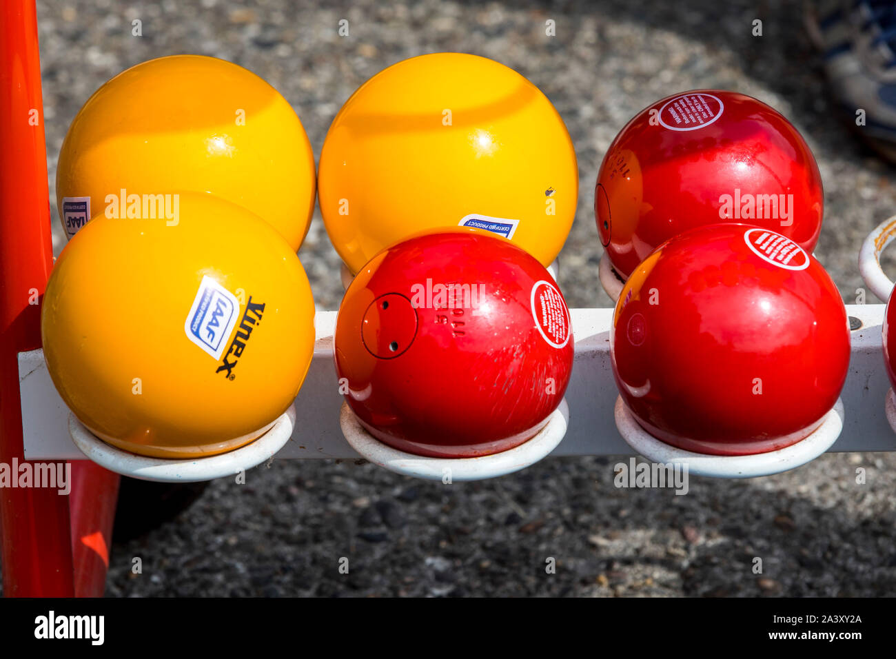 ball shots, metal balls, various weights, sizes, colors, on a sports field, track and field athletics Stock Photo