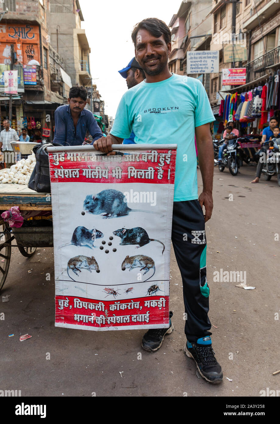 Indian man in the street with a billboard for pest control, Rajasthan