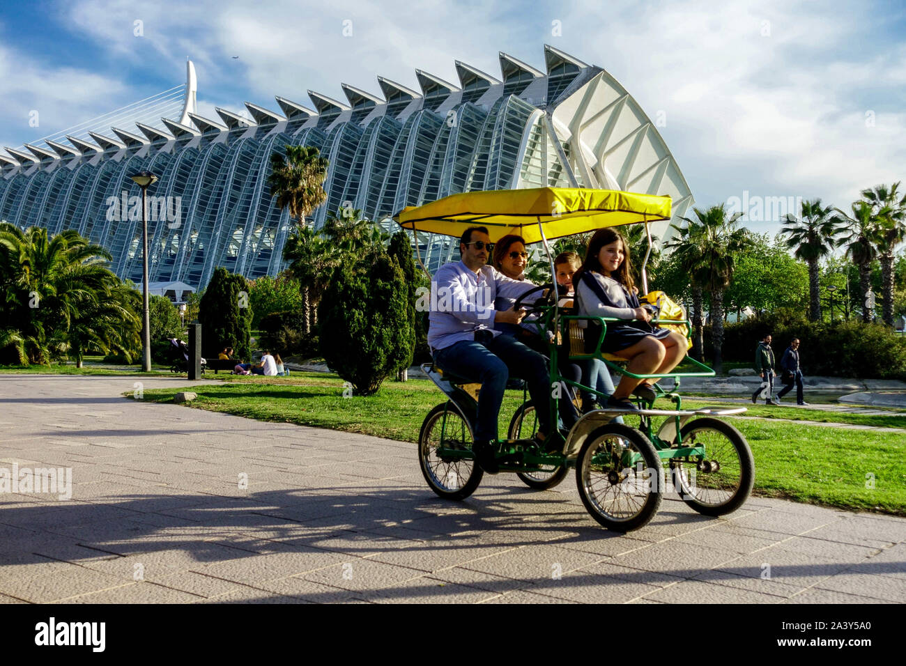 Valencia Spain People cycling on a bicycle in Turia Park Family on Qudracycle, Valencia City of Arts and Sciences, City park with modern architecture Stock Photo