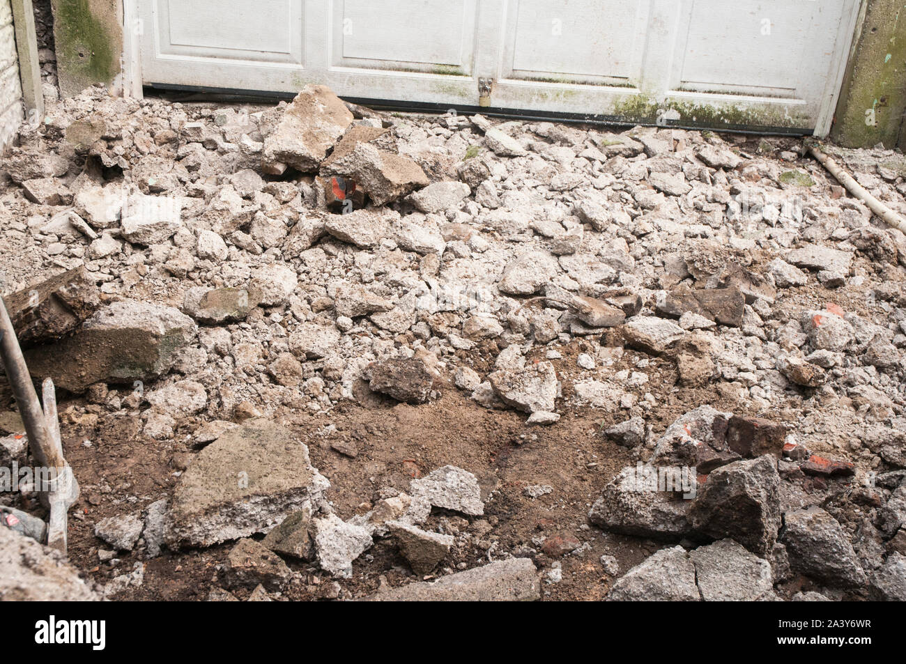 Broken up concrete rubble in a drive area ready to be removed for