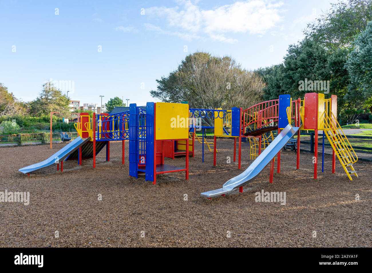 A colourful children's climbing frame with metal slides in a a children's park Stock Photo