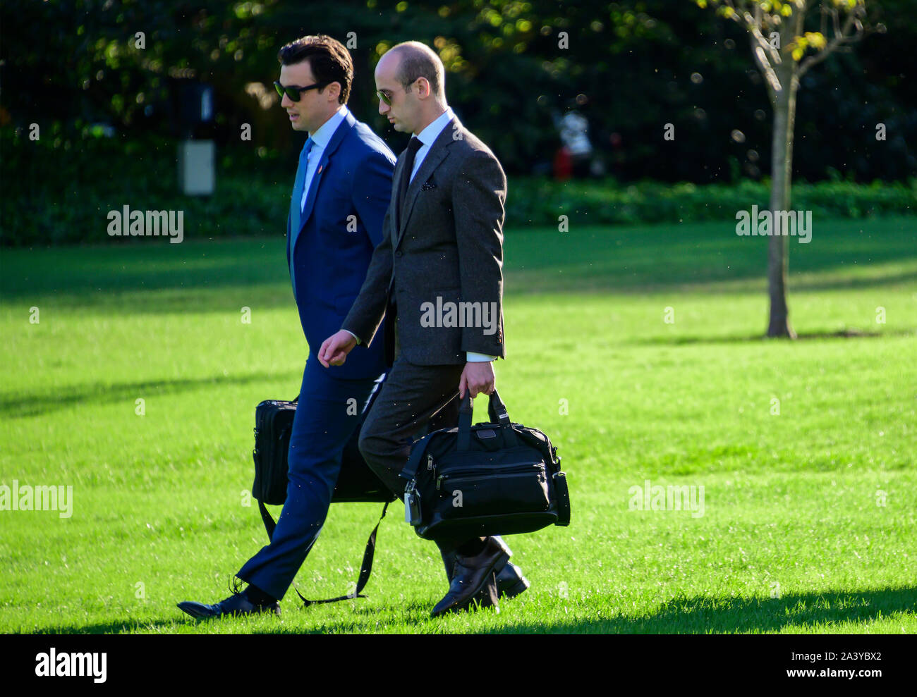 Deputy Assistant to the President for Operations and Personal Aide to the President Nicholas Luna, left and Senior Advisor for Policy Stephen Miller, right, walk across the South Lawn to accompany United States President Donald J. Trump as he prepares to depart the White House in Washington, DC to deliver remarks at a Keep America Great Rally in Minneapolis, Minnesota on Thursday, October 10, 2019.Credit: Ron Sachs/CNP | usage worldwide Stock Photo