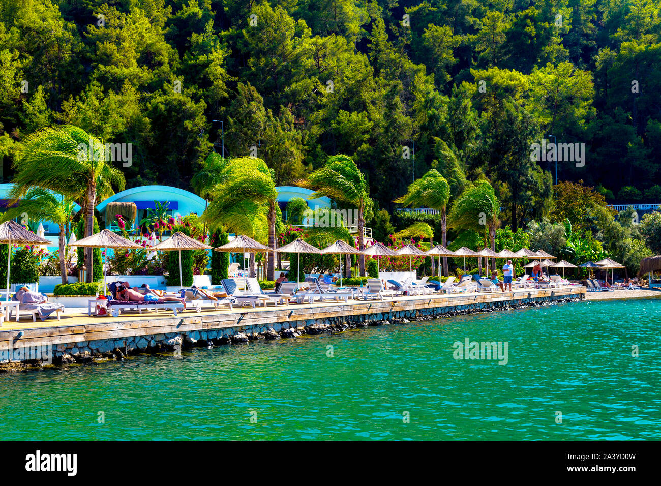Straw parasols and sun loungers at Yacht Classic Hotel Marina, Fethiye, Turkish Riviera, Turkey Stock Photo