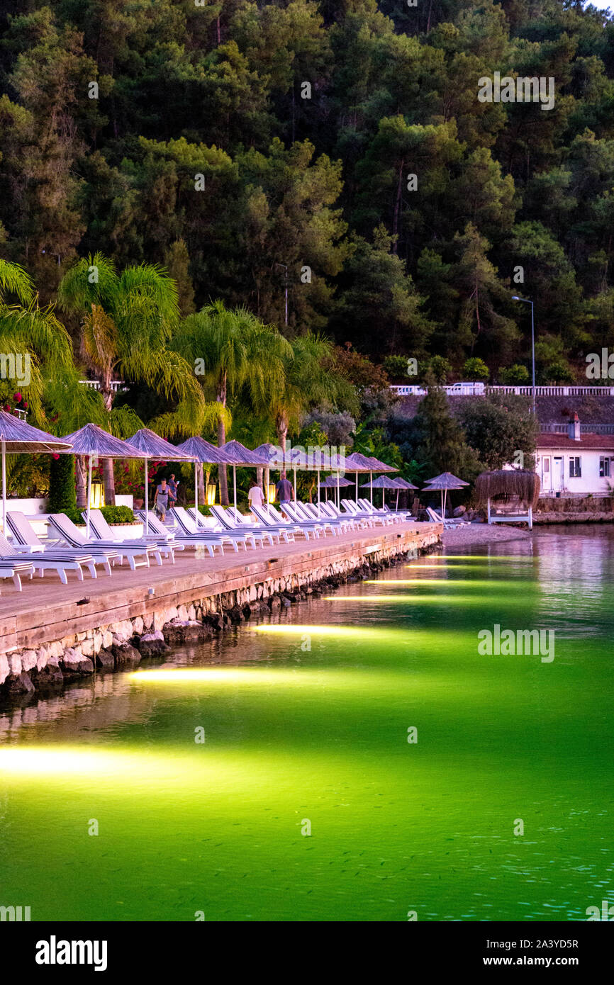 Sun loungers and parasols looking out to sea at the Yacht Classic Hotel, Ece Marina, Fethiye, Turkish Riviera, Turkey Stock Photo