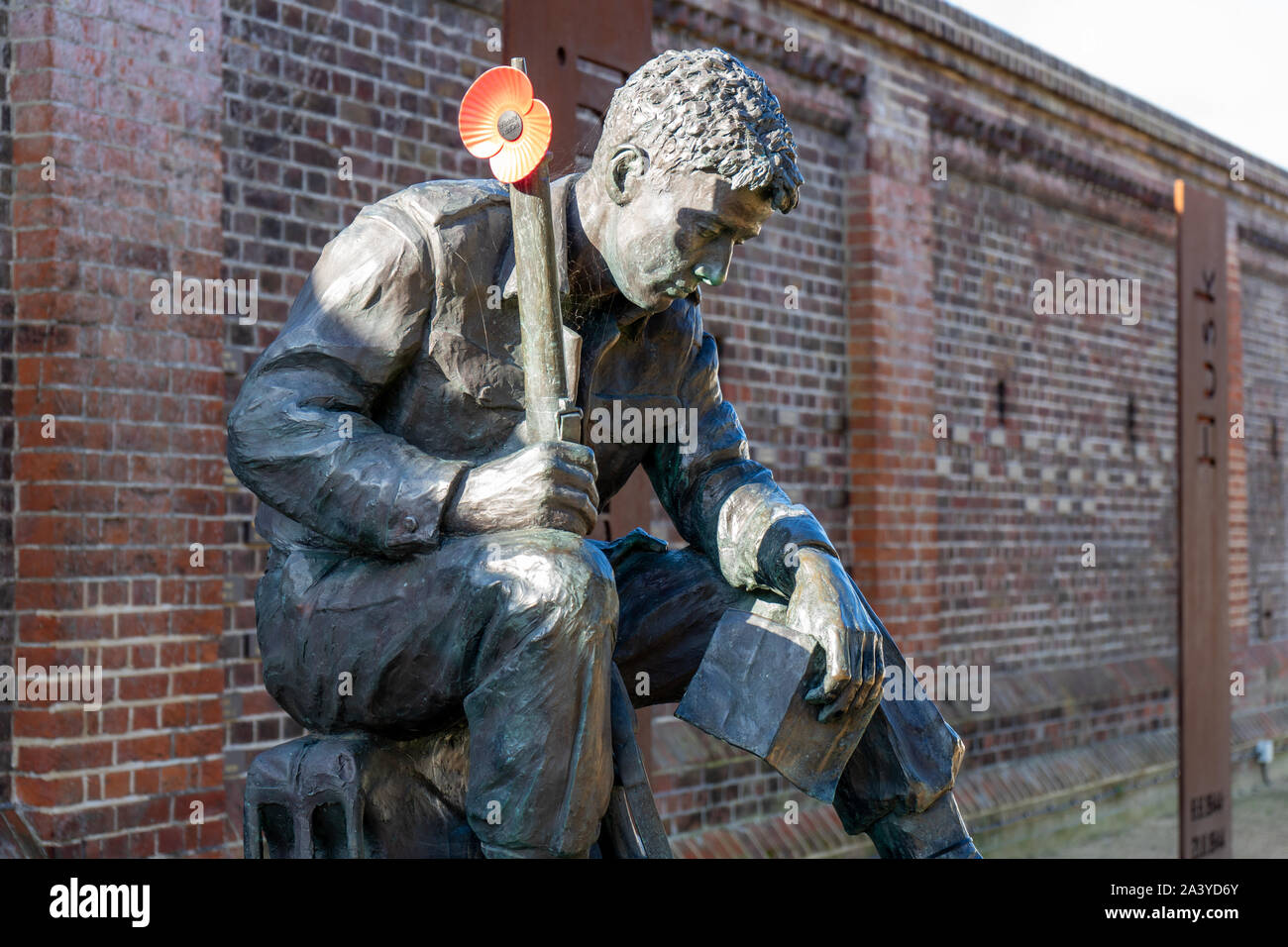 A statue of a world war two soldier with a poppy attached to his rifle Stock Photo