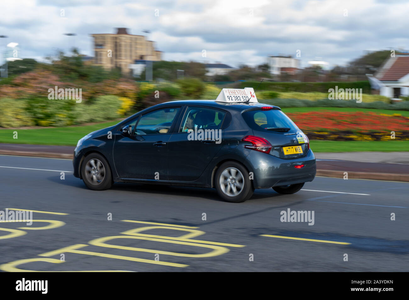 A driving instructors car moving along the road at speed with the learner driver driving during a driving lesson Stock Photo