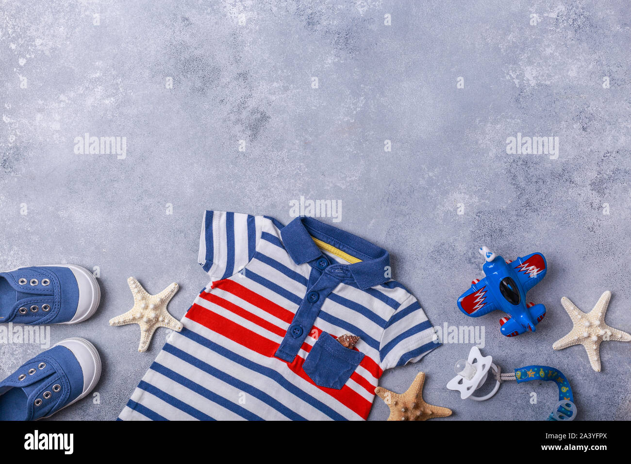 Small child or baby boy accessories on grey background travel with baby