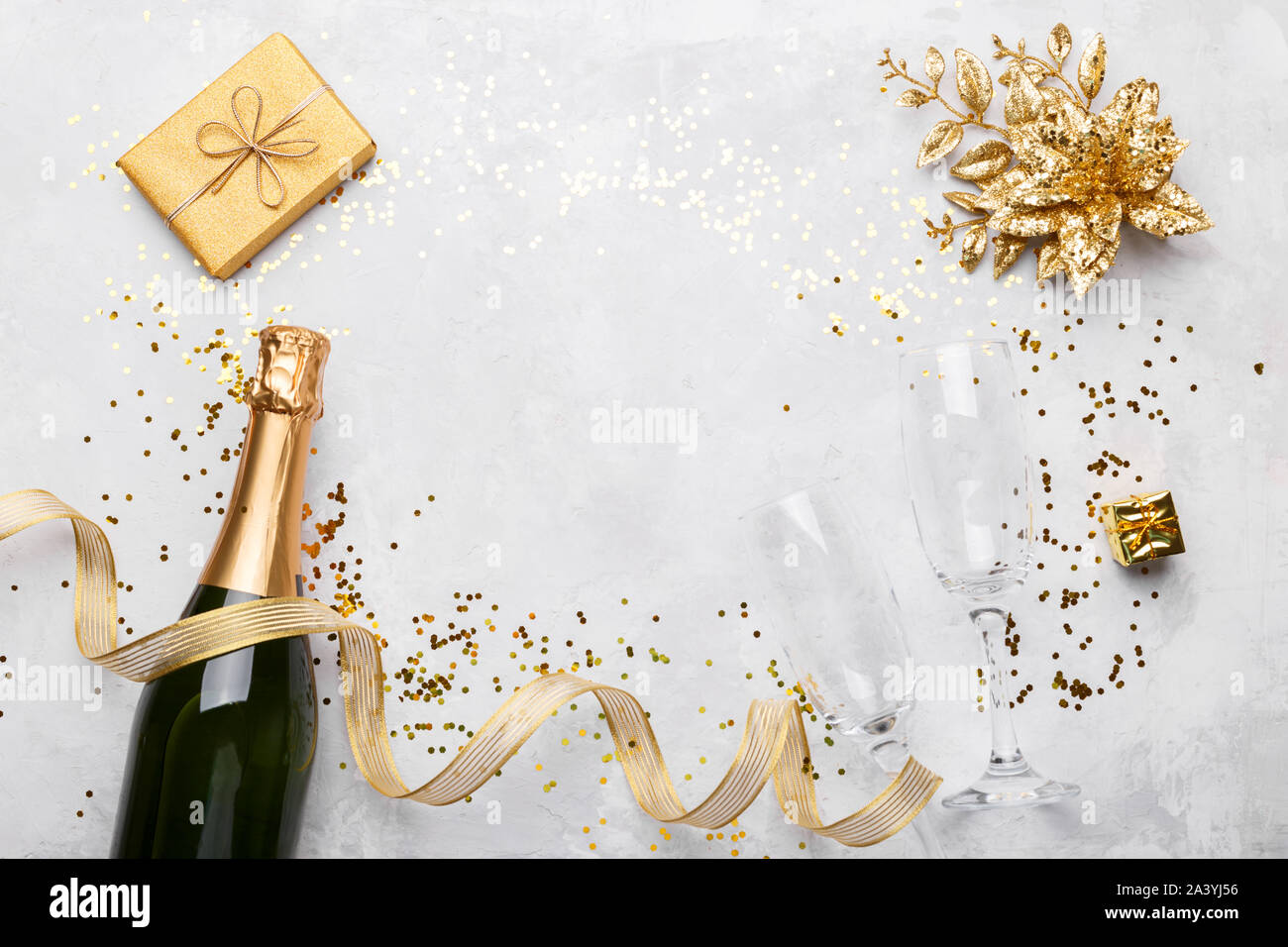 Flat lay composition of Champagne bottle golden gift box ribbons and  confetti on grey stone background copy space Stock Photo - Alamy