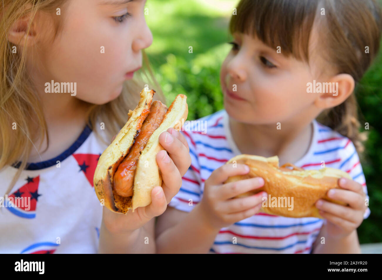 Girls eating hot dogs Stock Photo