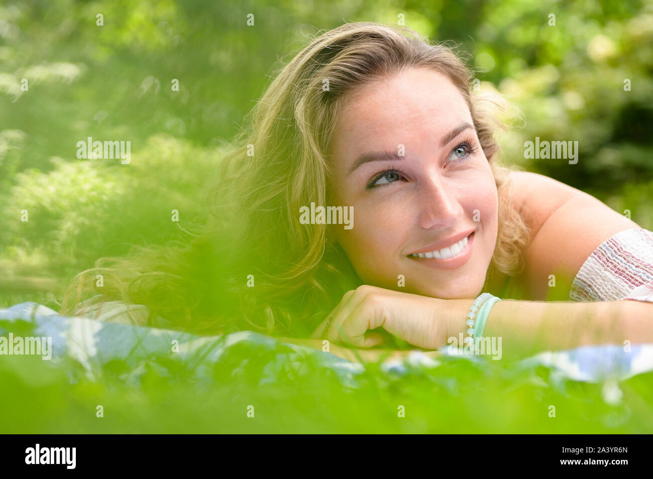 Smiling young woman lying in garden Stock Photo