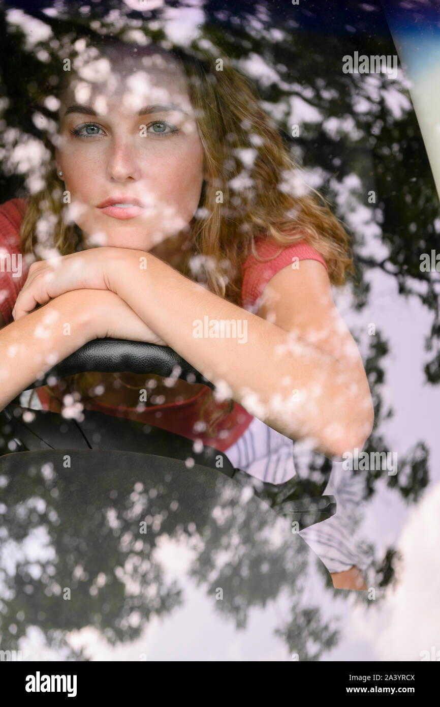 View through windscreen of young woman in car Stock Photo