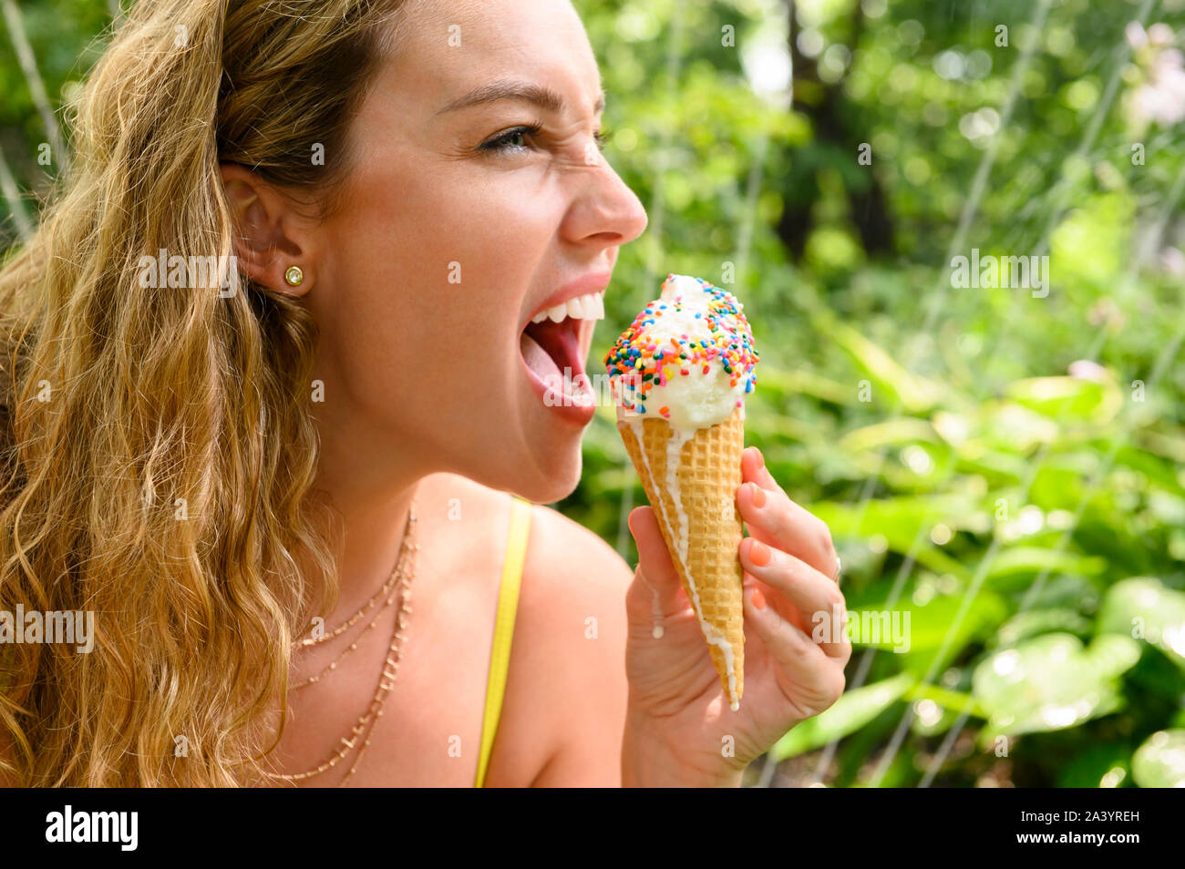 Young woman biting ice cream cone Stock Photo