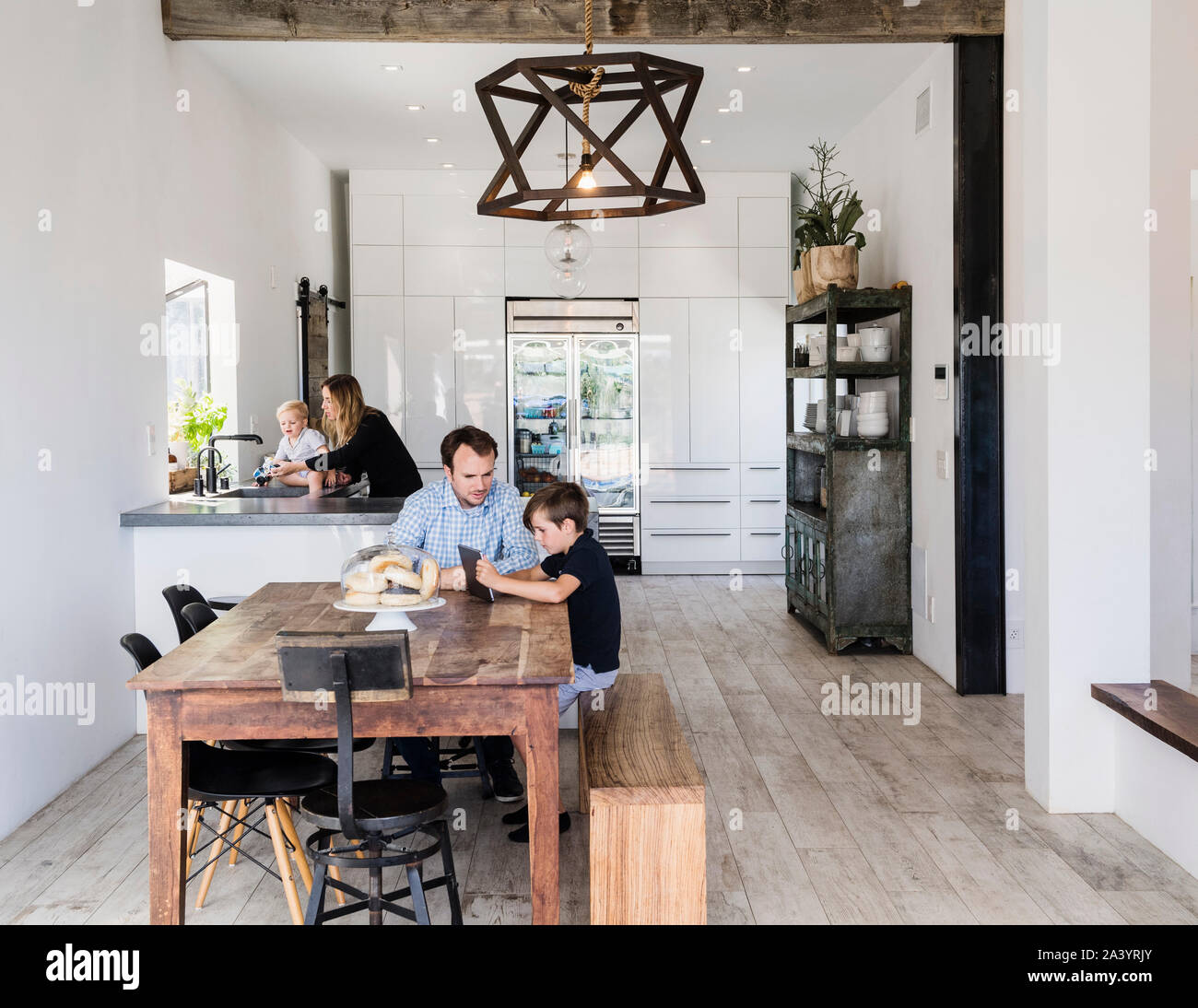 Father and son using digital tablet at dining table Stock Photo