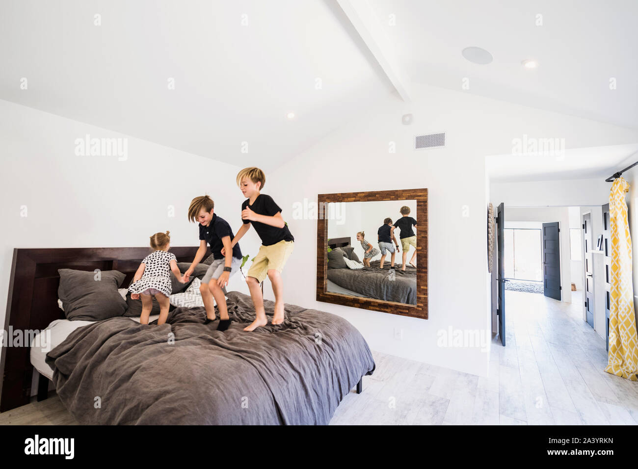 Children jumping on bed Stock Photo