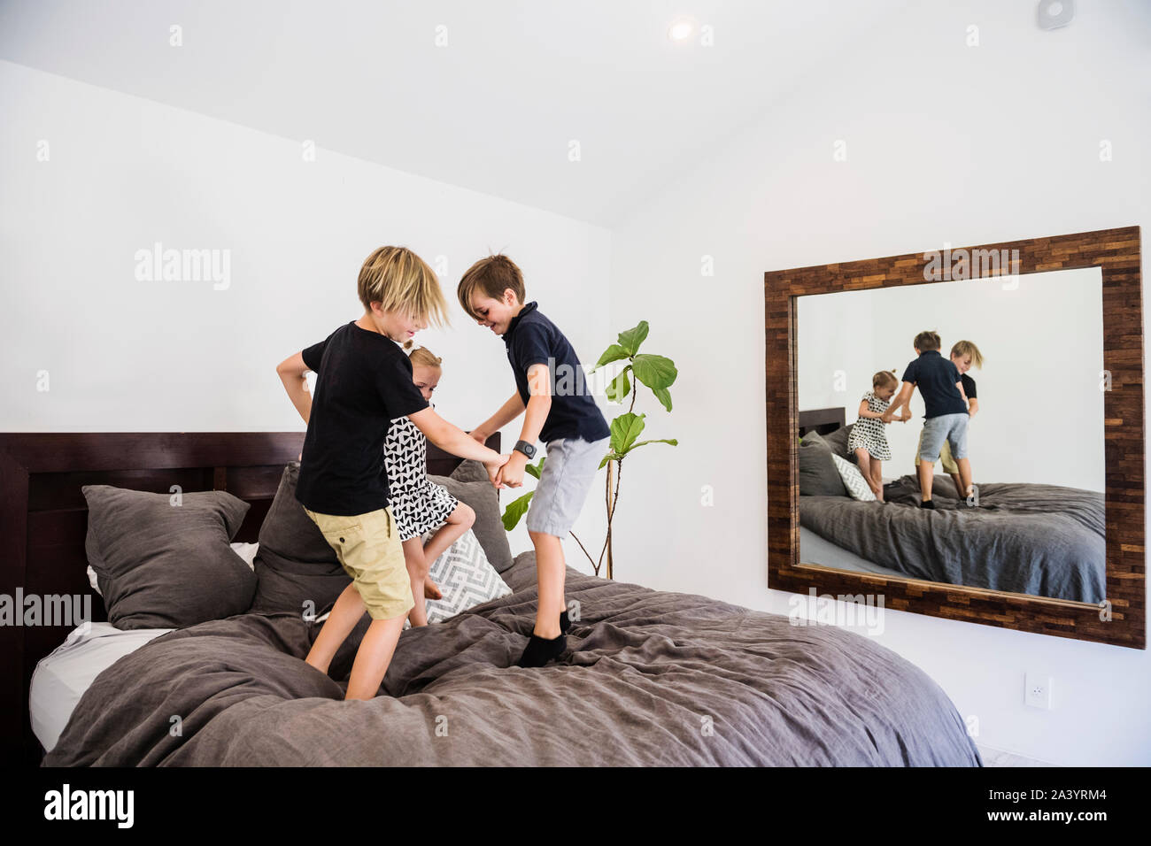 Children jumping on bed Stock Photo