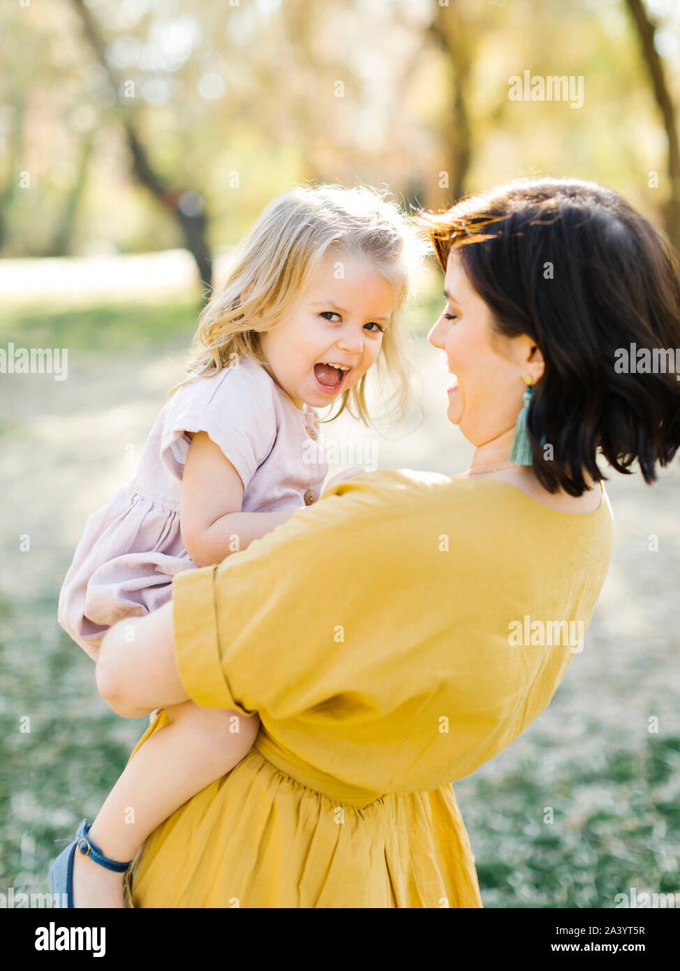 Mother holding her daughter in park Stock Photo