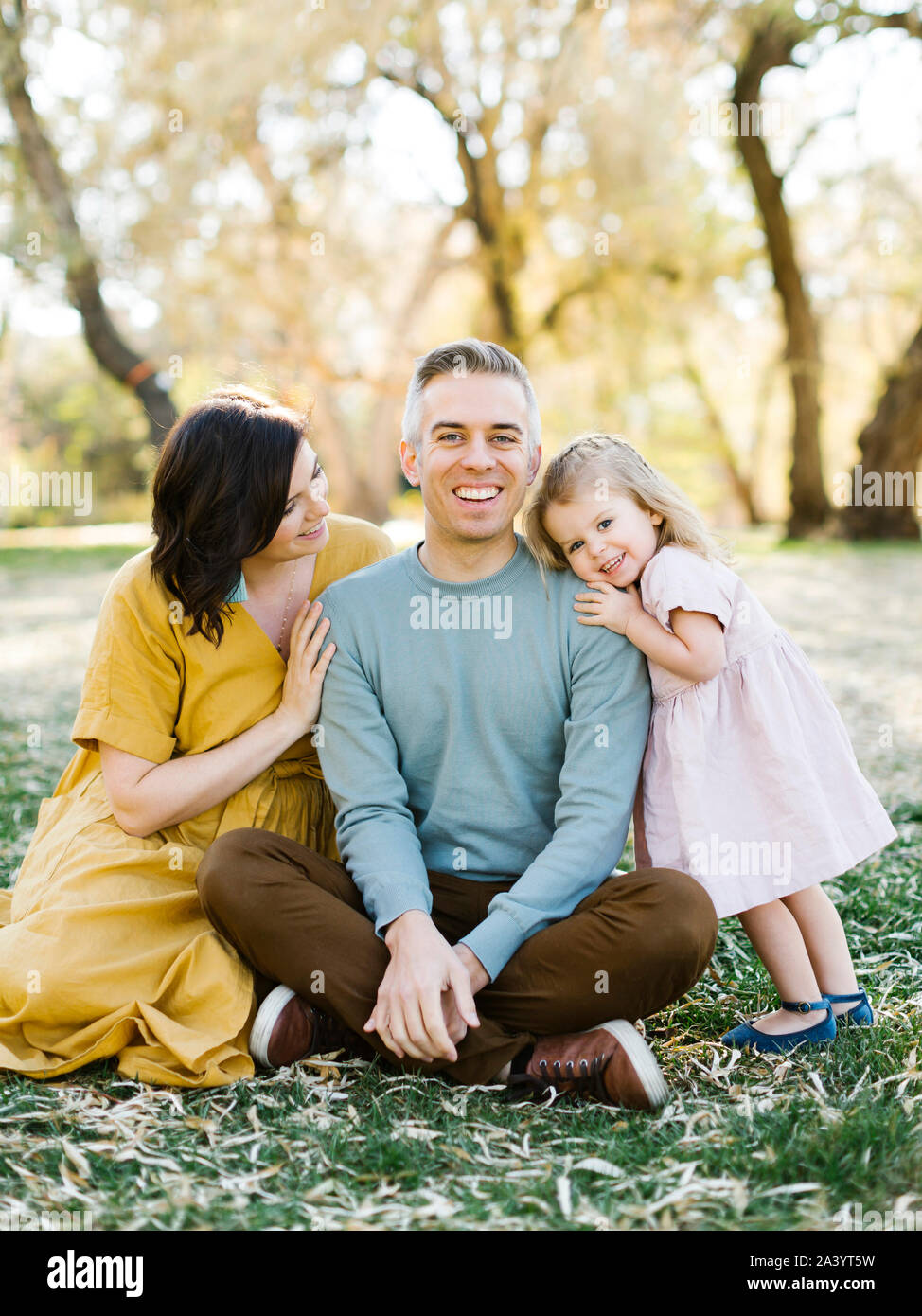 Mid adult couple sitting with their daughter in park Stock Photo