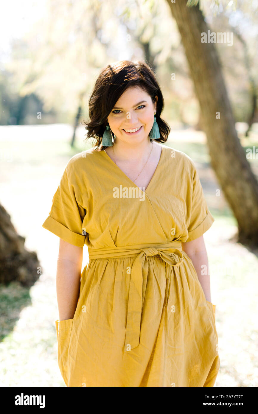 Woman smiling outdoors wearing yellow hi-res stock photography and ...