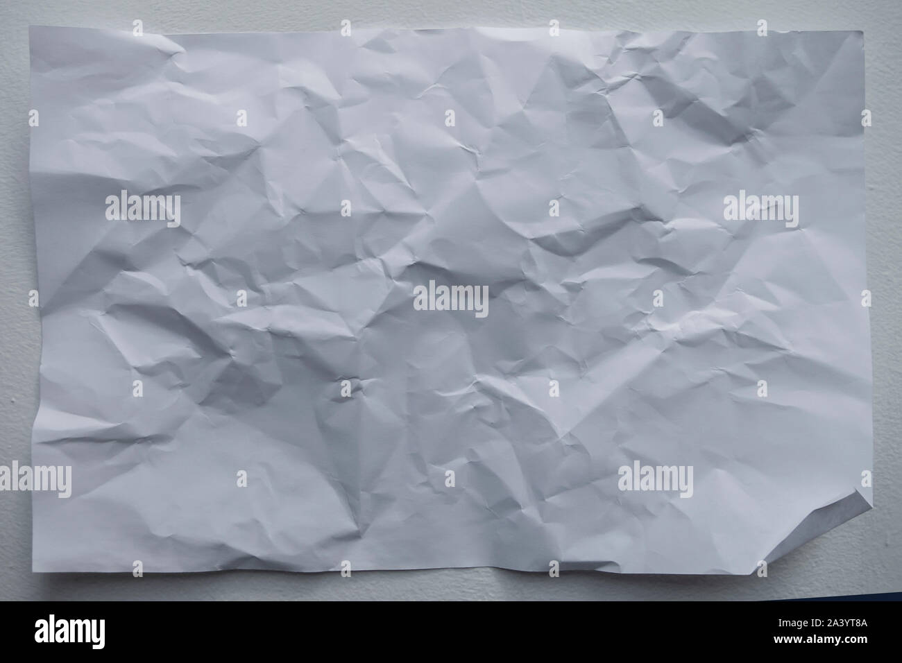 wrinled up white sheet of paper with creases and folds background Stock Photo