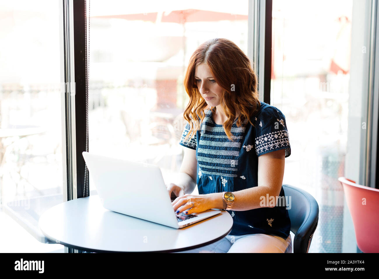 Woman using laptop in cafe Stock Photo