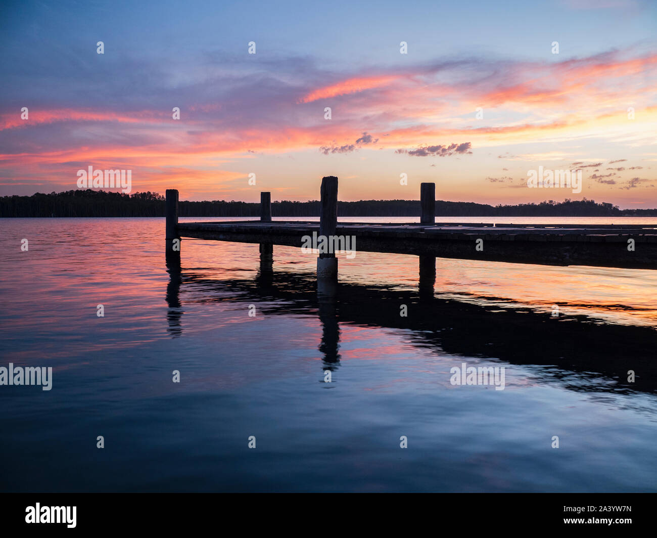 Jetty on river at sunset Stock Photo