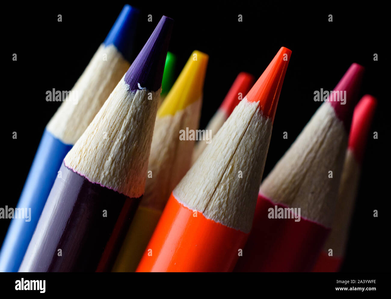 Closeup of bright wooden neon colored pencil tips isolated on black background Stock Photo
