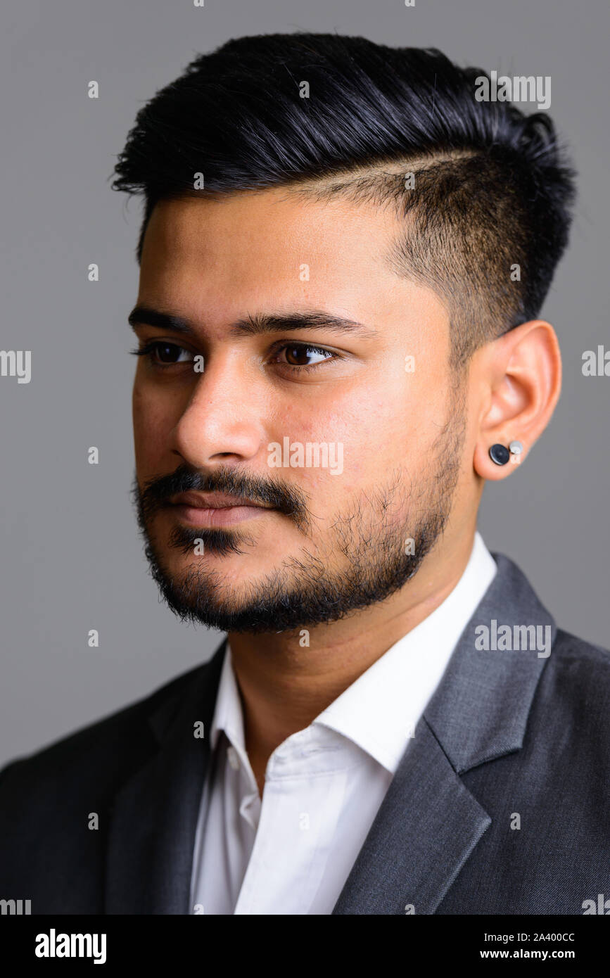 Face of young handsome Indian businessman thinking Stock Photo - Alamy