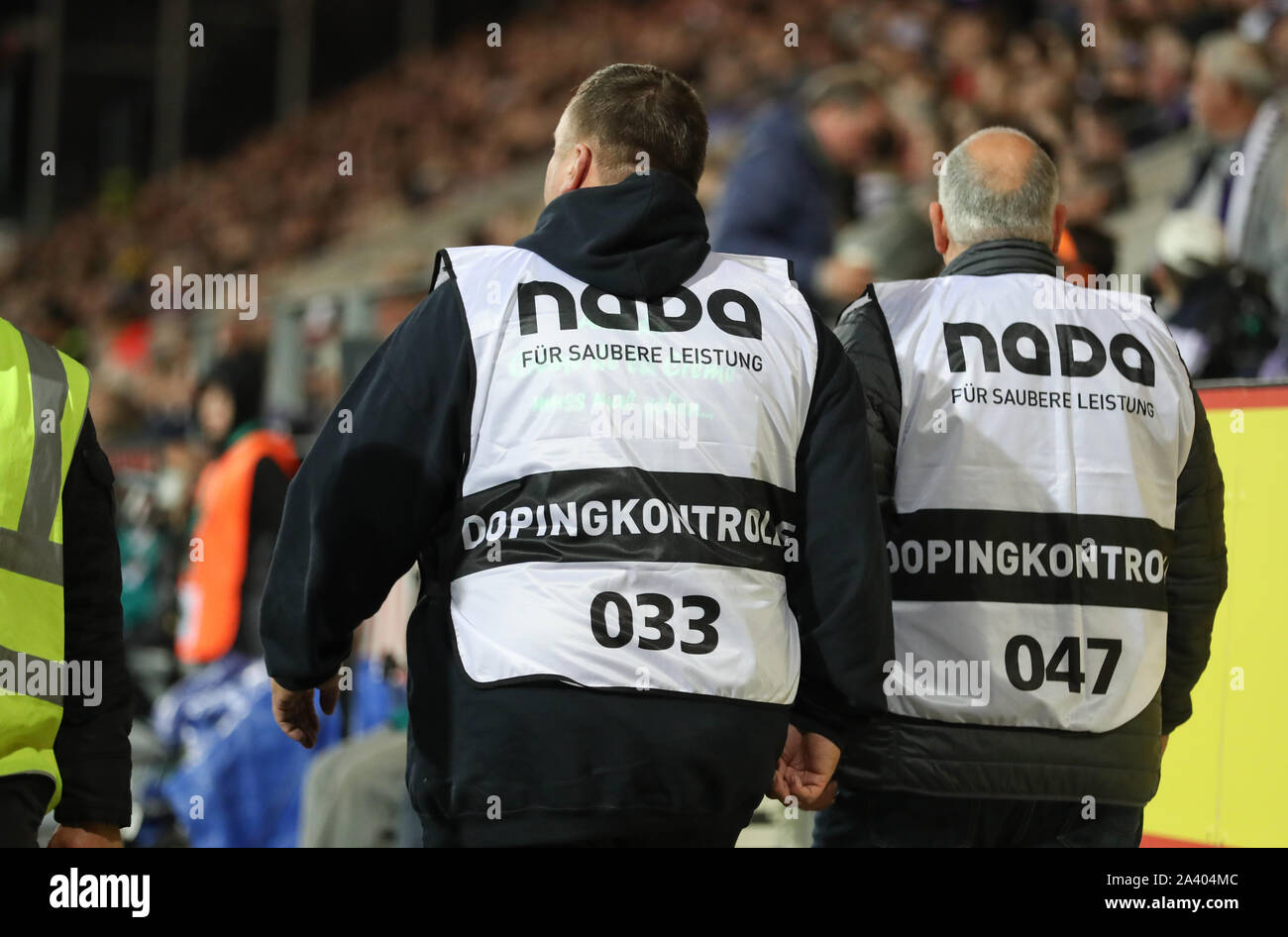07 October 2019, Lower Saxony, Osnabrück: Soccer: 2nd Bundesliga, VfL Osnabrück - Arminia Bielefeld, 9th matchday in the stadium at the Bremer Brücke. 'Doping Control' is on the bodice of two officials. Photo: Friso Gentsch/dpa - IMPORTANT NOTE: In accordance with the requirements of the DFL Deutsche Fußball Liga or the DFB Deutscher Fußball-Bund, it is prohibited to use or have used photographs taken in the stadium and/or the match in the form of sequence images and/or video-like photo sequences. Stock Photo