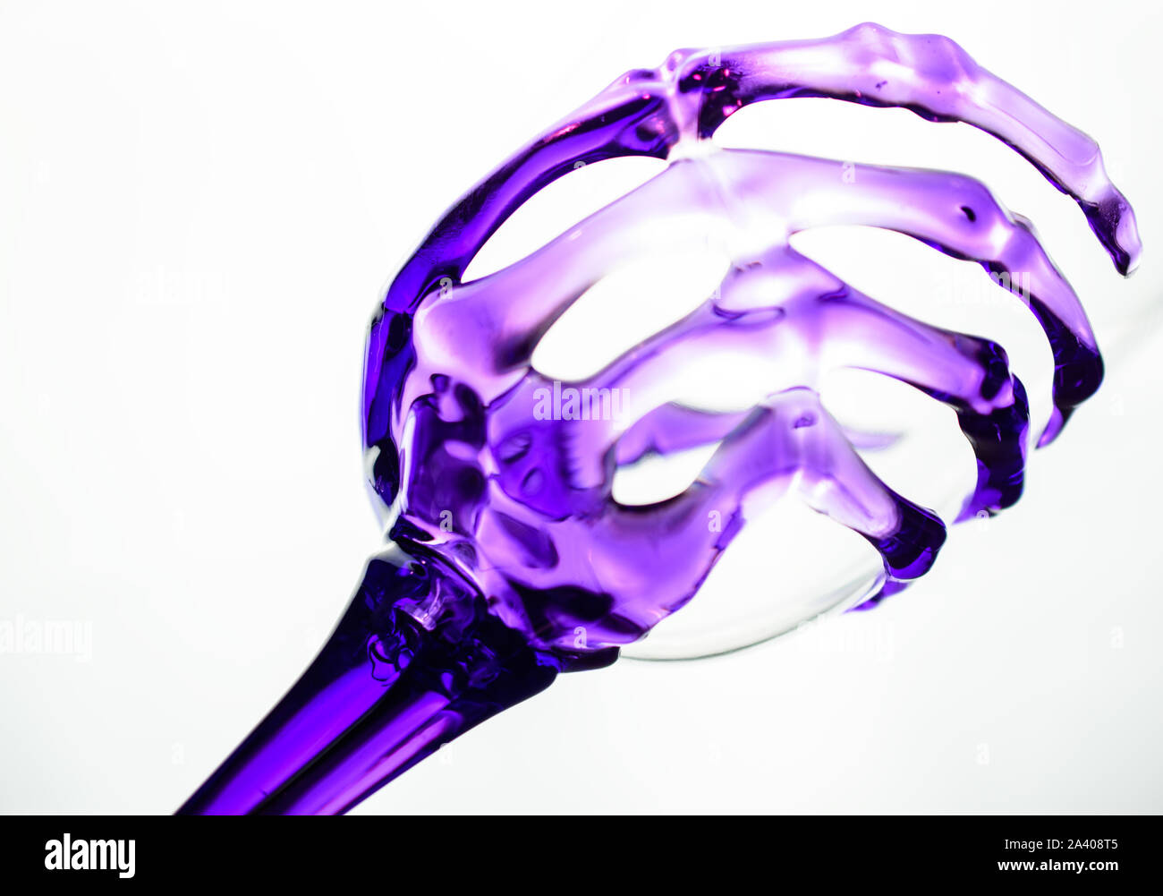 Cool Novelty Wine Glass with Transparent Purple  Skeleton Wrist and Hand making up the Stem and Gripping Bowl Stock Photo