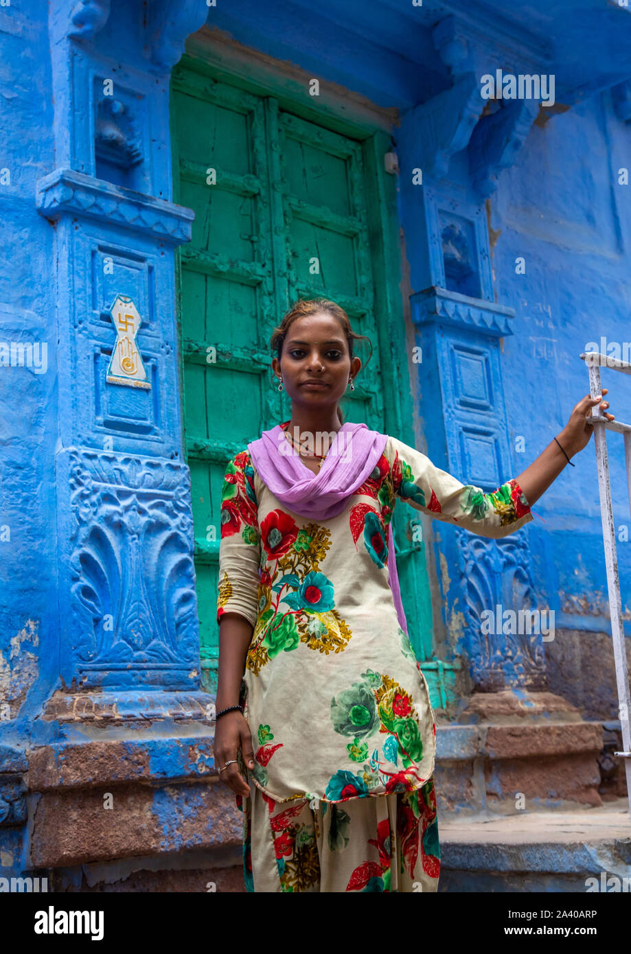 Portrait of a rajasthani teenage girl in traditional sari in front of a  blue house, Rajasthan, Jodhpur, India Stock Photo