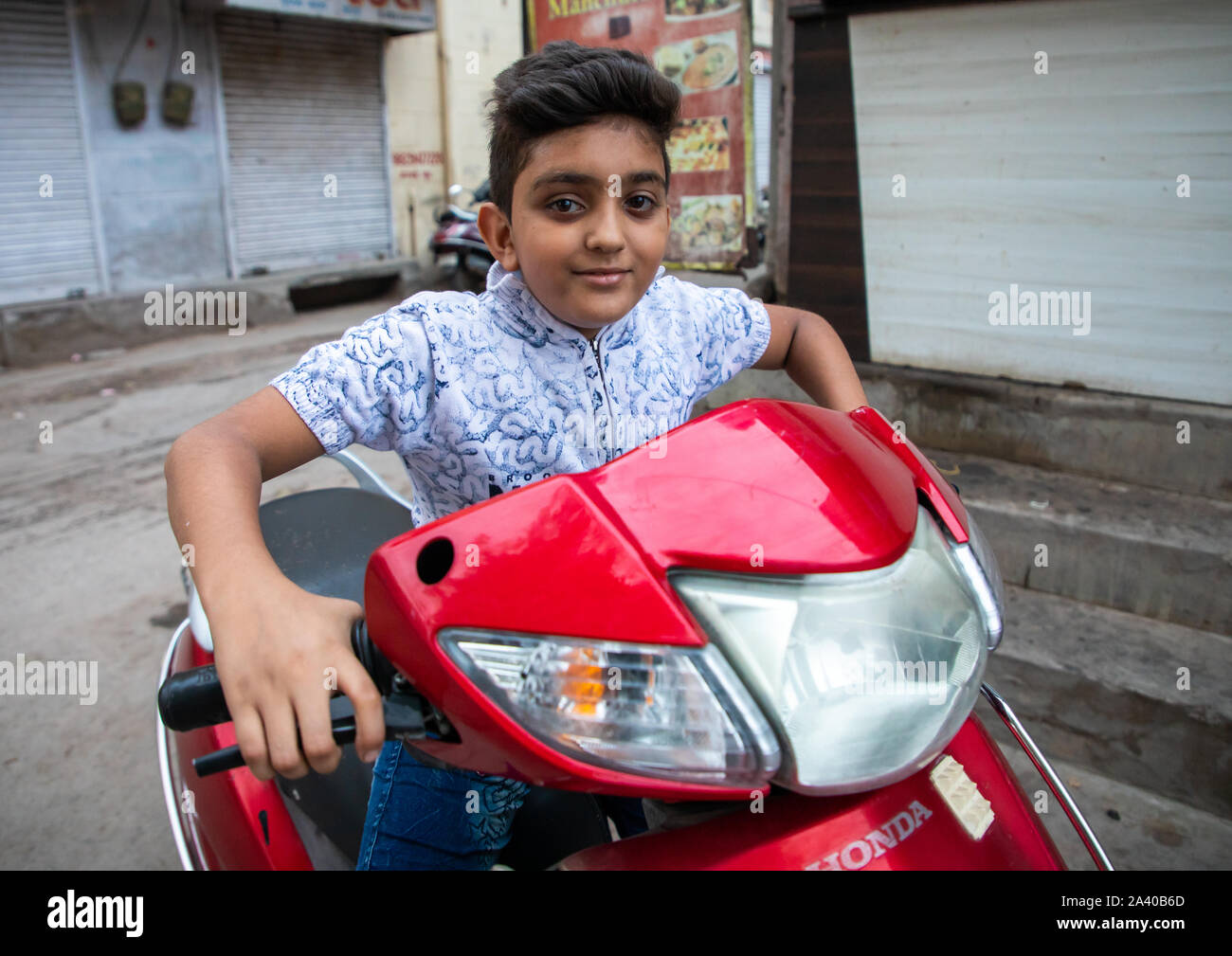 Portrait of a rajasthani boy riding a scooter, Rajasthan, Jodhpur ...