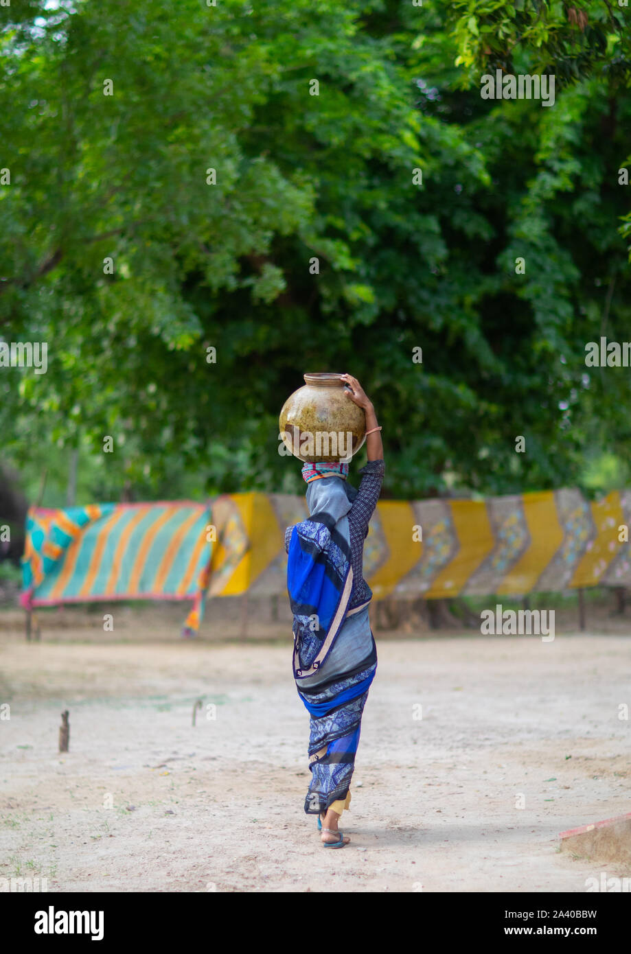 Indian woman carrying a jar on her head, Rajasthan, Baswa, India Stock Photo
