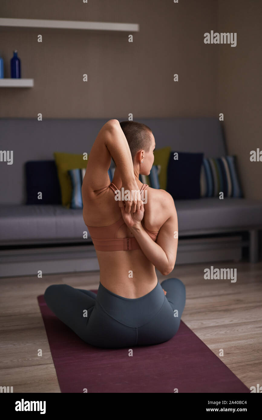 Young Woman Stretch Hands Sitting At Home On Purple Mat Flexible