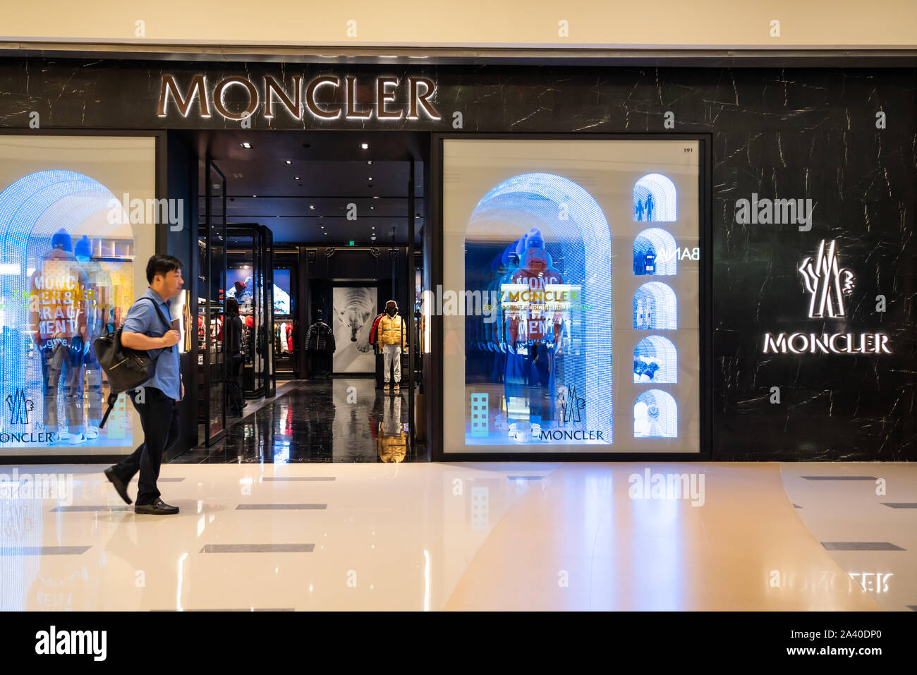 Pedestrians walk past an Italian apparel and lifestyle company Moncler  store in Shenzhen Stock Photo - Alamy