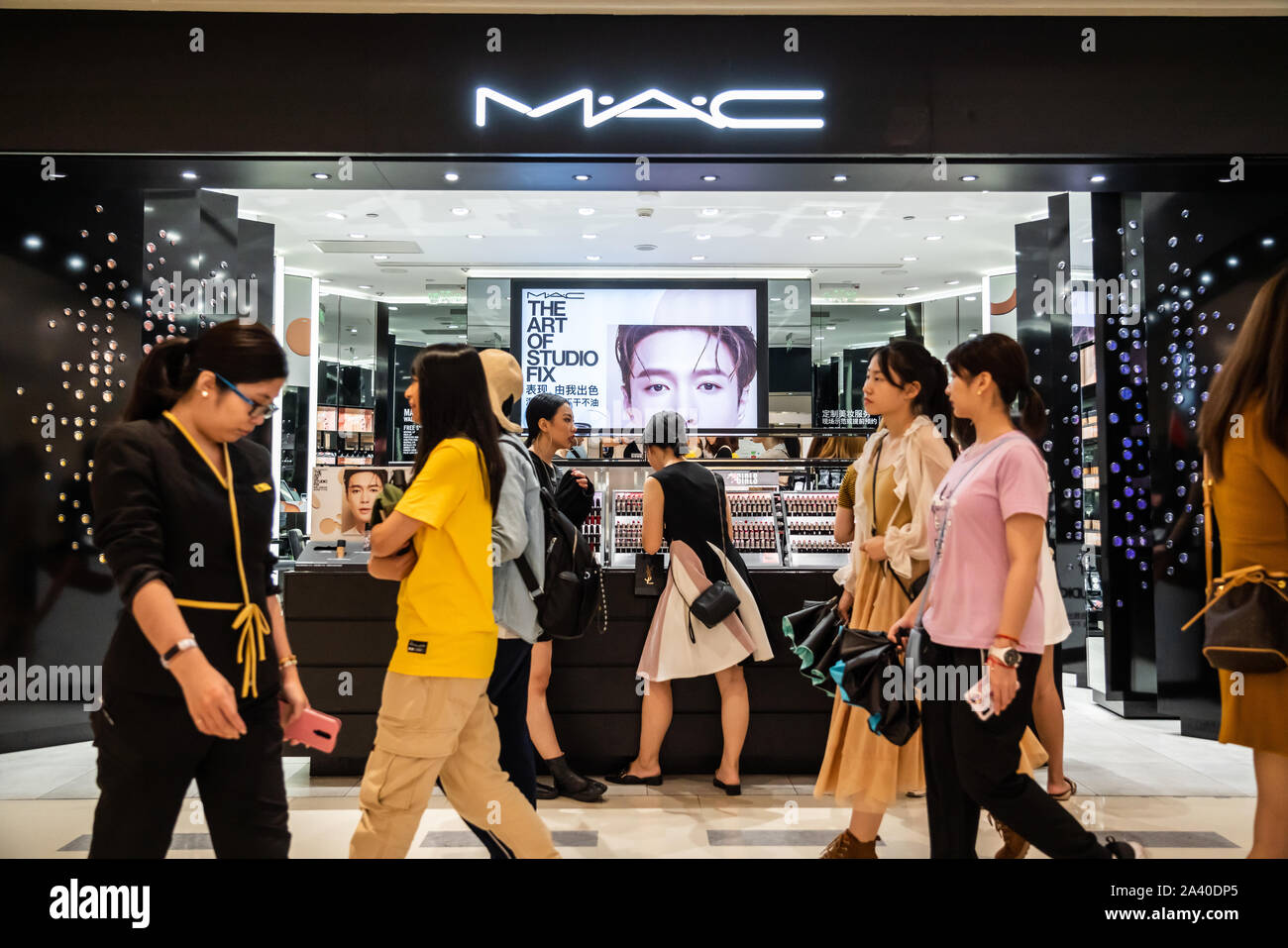 Pedestrians walk past a store of MAC Cosmetics, stylized as M·A·C, in Shenzhen. Stock Photo