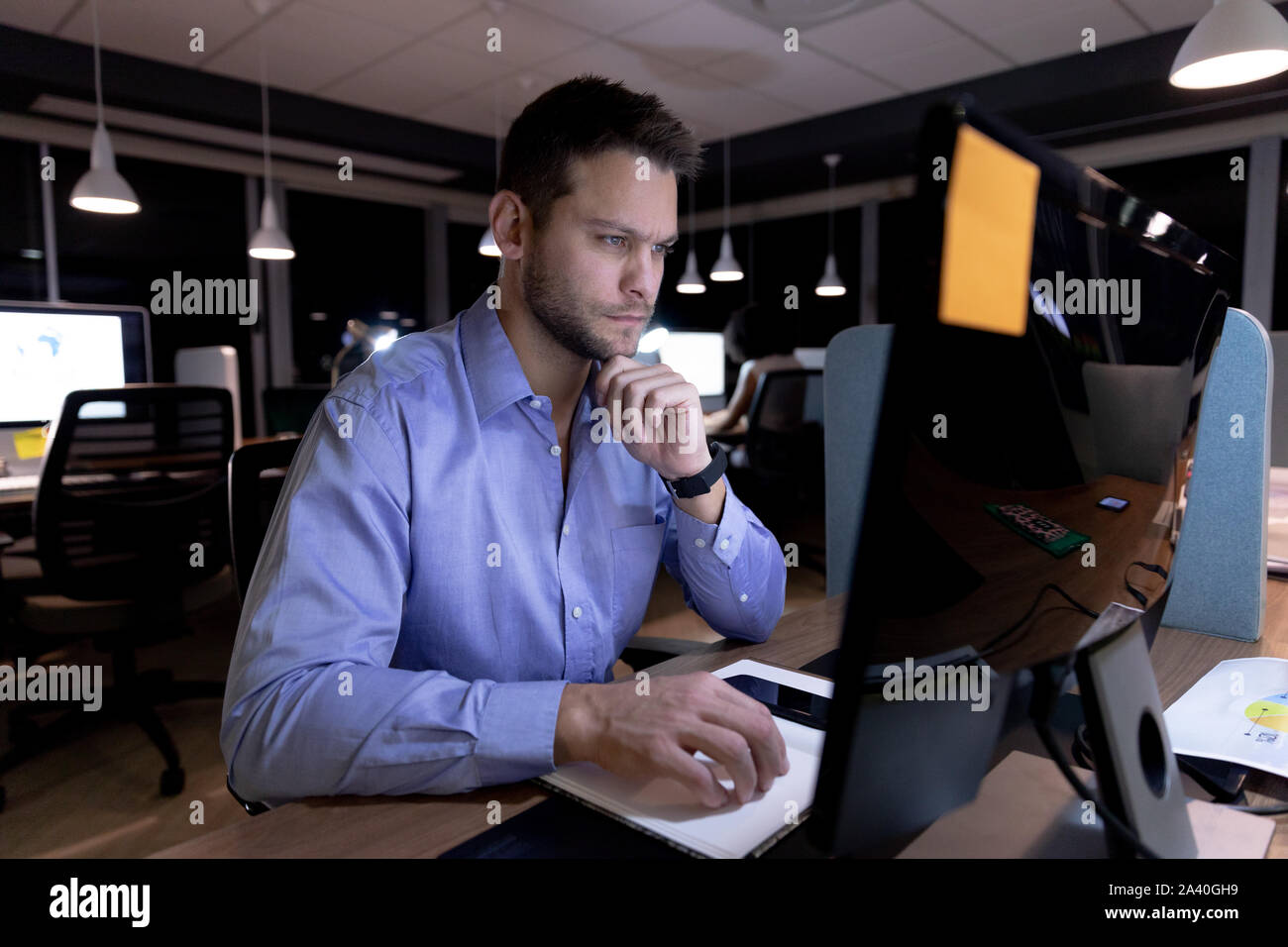 Young male professional working late in creative office Stock Photo