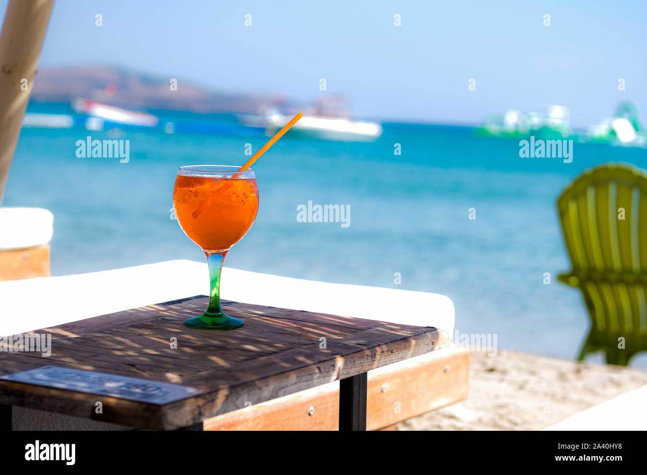 Orange drink or cocktail standing at the little table at the beach with sea background. Stock Photo