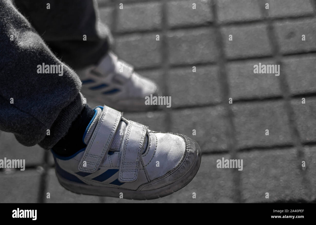 Legs of a little boy in tracksuit and running shoes that is resting and not  wanting to keep walking Stock Photo - Alamy
