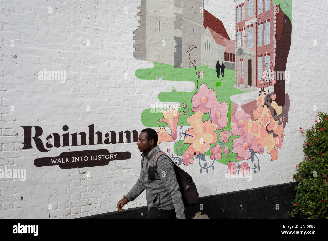 A local man walks past an artwork mural showing the small Essex town of Rainham, on 8th October 2019, in Rainham, Essex, England. Voters in this Havering borough voted 69% in favour of Brexit during the 2016 referendum. Stock Photo