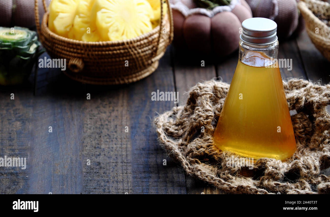Close up vegan dipping sauces bottle from pineapple slices with salt for Vietnamese vegetarian cuisine on black wooden background Stock Photo