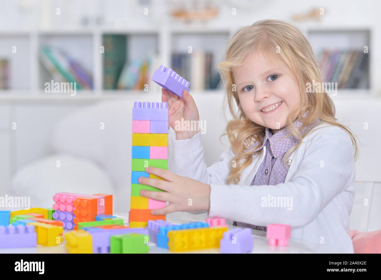 Little girl playing with colorful plastic blocks Stock Photo - Alamy